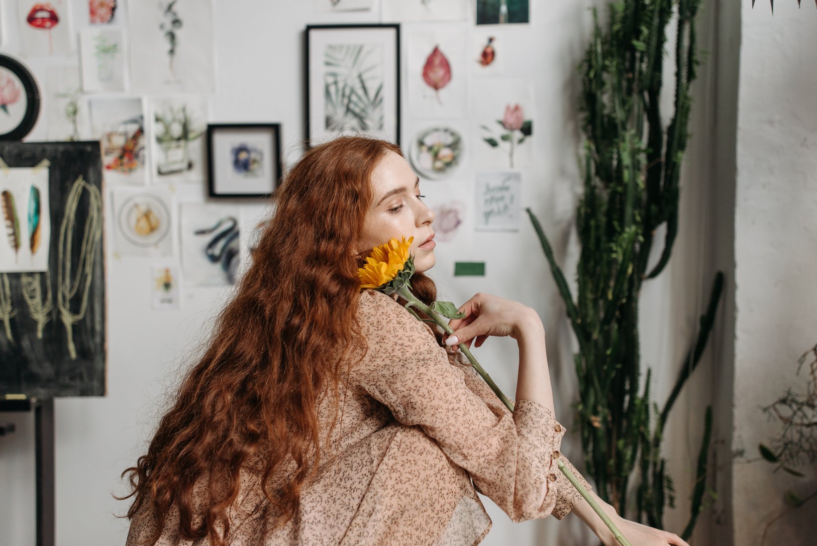 A Woman in Floral Top Holding a Sunflower